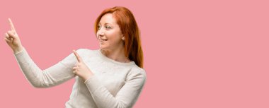 Güzel genç Kızıl saçlı kadın uzak yan parmak ile işaret