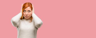 Güzel genç Kızıl saçlı kadın kulakları rahatsız edici gürültü, görmezden kapsayan takılan kulak işitme ses önlemek için. Gürültülü müzik bir sorundur.