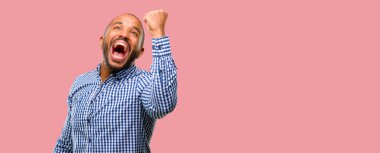 Mutlu ve heyecanlı kazanan jest ifade sakallı Afrikalı-Amerikalı adam. Başarılı ve zafer, zafer kutluyor