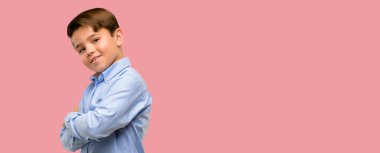 Kendinden emin ve mutlu bir büyük doğal gülümseme gülmek ile çapraz kollu yeşil gözlü yakışıklı yürümeye başlayan çocuk