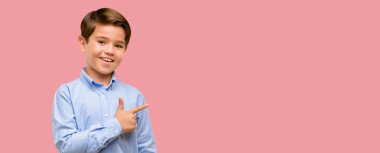 Uzak yan parmak ile işaret eden yeşil gözlü yakışıklı yürümeye başlayan çocuk