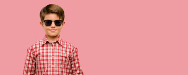 Kendinden emin ve mutlu kameraya bakarak büyük bir doğal gülümseme ile yeşil gözlü yakışıklı yürümeye başlayan çocuk