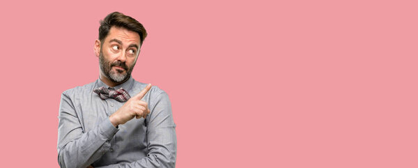 Middle age man, with beard and bow tie pointing away side with finger