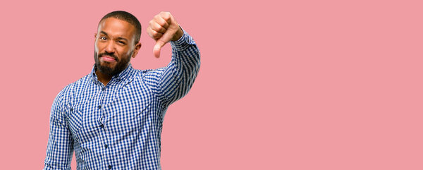 African american man with beard showing thumbs down unhappy sign of dislike, negative expression and disapproval