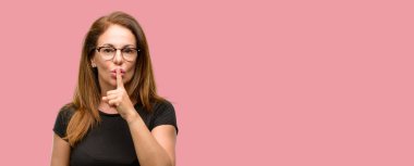 Siyah gömlek ve işaret parmağı ile gözlük dudaklarından, giyen orta yaş kadın sormak sessiz olmalısın. Sessizlik ve gizli kavramı