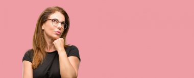 Orta yaş kadın siyah gömlek ve düşünme ve şüphe ve merak ifade arıyorum gözlük