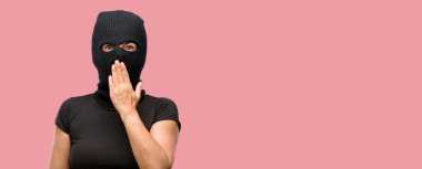 Yün kar maskesi giyen hırsız terörist kadın şok ağzına kapakları, sessizlik ve hata kavramlar, korkmuş ifade utangaç, görünüyor