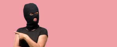 Yün kar uzak yan parmak ile işaret maskesi giyen hırsız terörist kadın