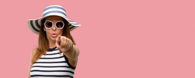 Orta yaş serin yaz şapka ve güneş gözlüğü parmak ile ön işaret giyen kadın