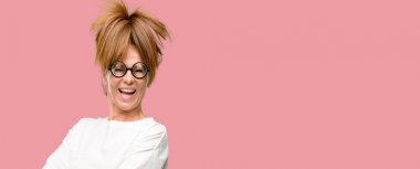 Kendinden emin ve mutlu bir büyük doğal gülümseme gülmek ile çapraz kollu saçma gözlük takan deli orta yaş kadın