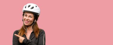 Orta yaş bisikletçi kadın uzak yan parmak ile işaret kulaklık kullanarak