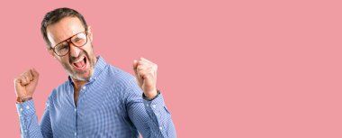 Yakışıklı orta yaş adam mutlu ve heyecanlı kazanan jest ifade. Başarılı ve zafer, zafer kutluyor