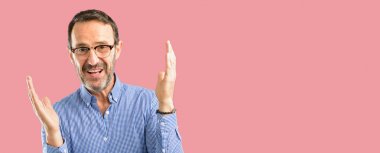 Yakışıklı orta yaş adam kendinden emin ve mutlu bir büyük doğal gülümseme hoş geldiniz hareketi ile