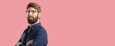 Kendinden emin ve mutlu bir büyük doğal gülümseme gülmek ile çapraz kollu büyük sakallı genç hipster adam