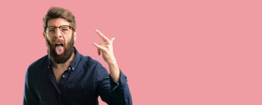 Rock simge elle yapma, bağırarak ve dilini çıkarmış kutluyor büyük sakallı genç hipster adam