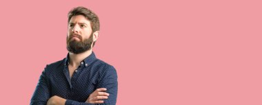 Kendinden emin ve mutlu bir büyük doğal gülümseme gülmek ile çapraz kollu büyük sakallı genç hipster adam