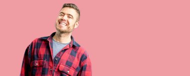 Genç yakışıklı adam kendinden emin ve mutlu bir büyük doğal gülümseme gülmüyorum, doğal ifade ile