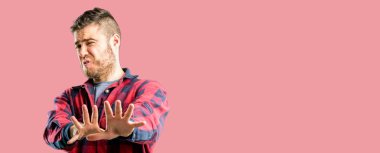 Dur jest, bir savunma olarak ellerini tutmak, bağırarak yakışıklı delikanlı tiksinti ve kızgın,