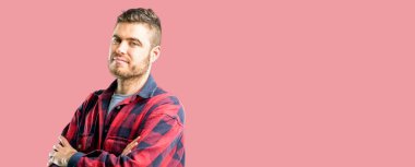 Kendinden emin ve mutlu bir büyük doğal gülümseme gülmek ile çapraz kollu yakışıklı delikanlı