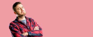 Kendinden emin ve mutlu bir büyük doğal gülümseme gülmek ile çapraz kollu yakışıklı delikanlı