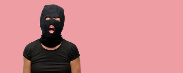 窃贼的恐怖女人穿着巴拉克拉瓦滑雪面罩压力重重 惊恐万分 大喊恼怒和沮丧 不愉快的手势 烦人的工作让我发疯 — 图库照片