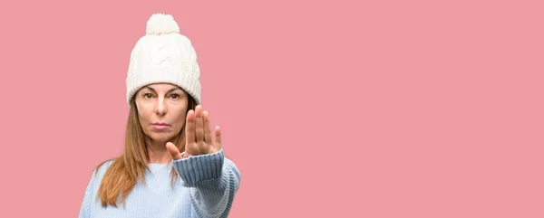 中年女性着てウール防寒帽手 セキュリティ 防衛または多分プッシュ制限を表現する ノーというと一時停止の標識を作る悪い姿勢で腹が立つ — ストック写真