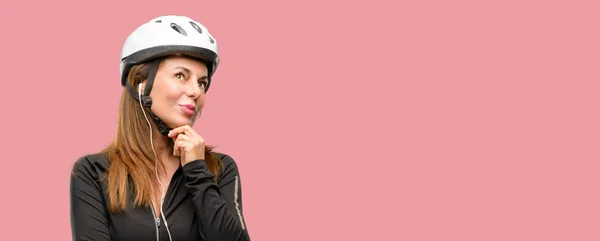 中年骑自行车的妇女用耳机思考和寻找表达怀疑和疑惑 — 图库照片