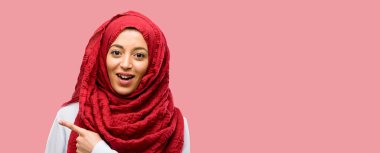 Uzak yan parmak ile işaret hijab giyen genç Arap kadın