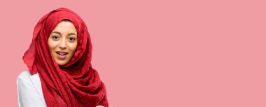 Bir şey boş elinde tutan hijab giyen genç Arap kadın