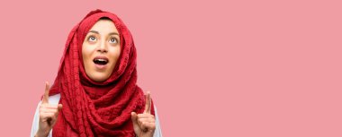 Mutlu ve yukarı dönük ifade wow jest tezahürat hijab giyen genç Arap kadın