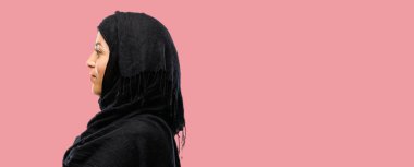 Kendinden emin ve mutlu bir büyük doğal gülümseme gülmek ile çapraz kollu hijab giyen genç Arap kadın