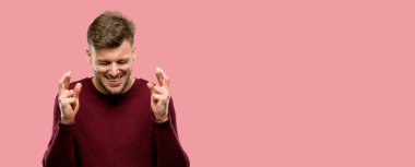 Şans getirsin diye soran kenetlenmiş parmaklar ile yakışıklı genç