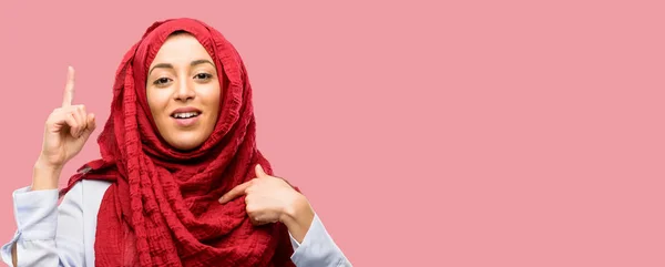 年轻的阿拉伯妇女戴着头巾高兴和惊讶的欢呼声表示哇姿态指向 — 图库照片