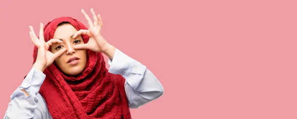 Młoda Kobieta Arabska Noszenie Hidżabu Patrząc Kamery Przez Jej Palce — Zdjęcie stockowe