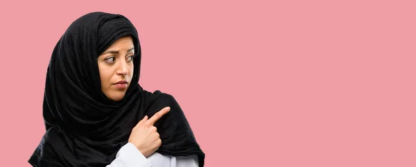 戴头巾的年轻阿拉伯妇女用手指指向一边 — 图库照片