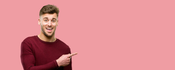 Handsome young man pointing away side with finger