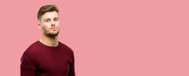 Yakışıklı genç adam kendinden emin ve mutlu kameraya bakarak büyük bir doğal gülümseme ile