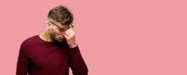 Çok çalışan ve yorgun, rubbes burun yorgunluk nedeniyle olmak uykulu ifade, yakışıklı genç adam