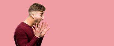 Yakışıklı genç adam stresli kafasına, panik içinde dehşete ellerini tutmak, bağırarak