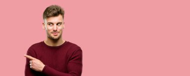 Uzak yan parmağıyla işaret yakışıklı genç