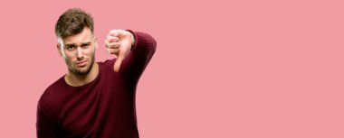 Başparmak aşağı sevmemek, negatif ifade ve ret mutsuz işareti gösterilen yakışıklı genç