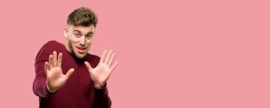 Dur jest, bir savunma olarak ellerini tutmak, bağırarak yakışıklı genç adam tiksinti ve kızgın,