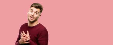 Çekici gülümseme sevgi ve sempati göstermek isteyen kalp üzerinde el ele tutuşarak sahip yakışıklı genç