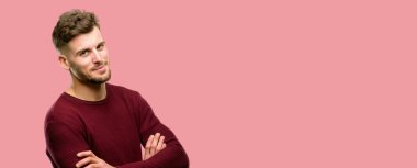 Kendinden emin ve mutlu bir büyük doğal gülümseme gülmek ile çapraz kollu yakışıklı genç