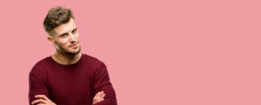 Kendinden emin ve mutlu bir büyük doğal gülümseme gülmek ile çapraz kollu yakışıklı genç