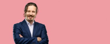 Kendinden emin ve mutlu bir büyük doğal gülümseme gülmek ile çapraz kollu yakışıklı genç