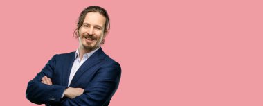 Kendinden emin ve mutlu bir büyük doğal gülümseme gülmek ile çapraz kollu yakışıklı genç