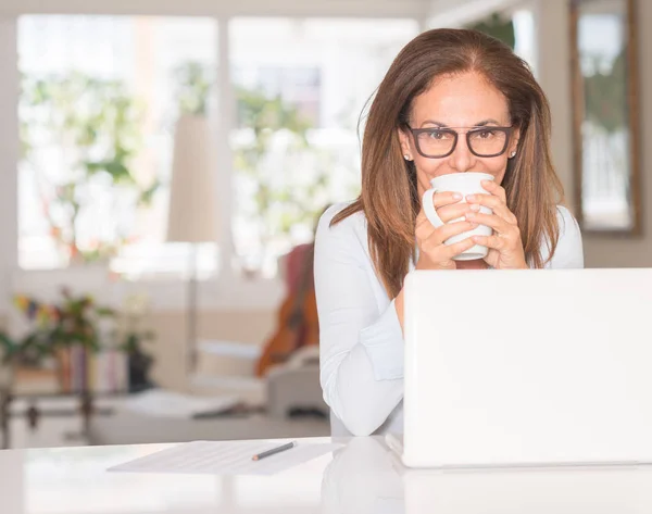 中年妇女使用计算机和饮用咖啡 — 图库照片