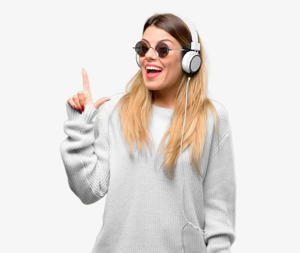 Mujer Joven Escuchar Música Con Auriculares Apuntando Hacia Lado Con —  Fotos de Stock