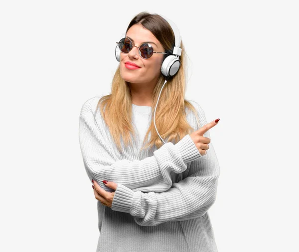 Mujer Joven Escuchar Música Con Auriculares Apuntando Hacia Lado Con —  Fotos de Stock